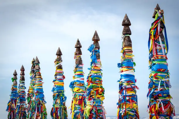 Sacred pillars with tied ribbons on Cape Burhan of Olkhon Island. Buryat traditions. Shamanistic and buddic rites of Lake Baikal. Olkhon Island, Baikal Lake , Buryatia republic Russia