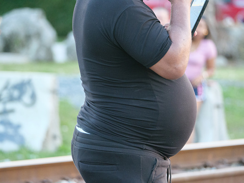 A man with a distended belly in black clothes photo of USA's problem with over eating and obesity