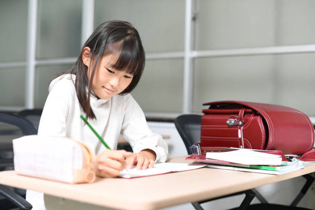 asiatisches grundschulmädchen lernt im klassenzimmer - randoseru ranzen stock-fotos und bilder