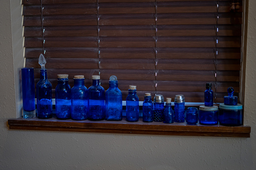 Vintage glass bottles on the kitchen table. Interior of private home in winter.