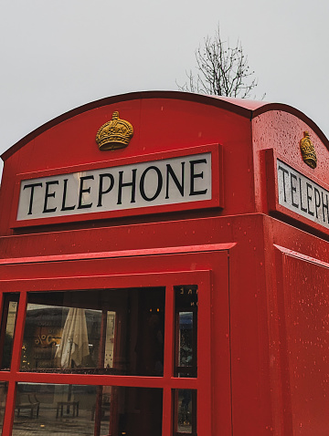 a close-up view of a nostalgic red telephone booth with a royal crown emblem