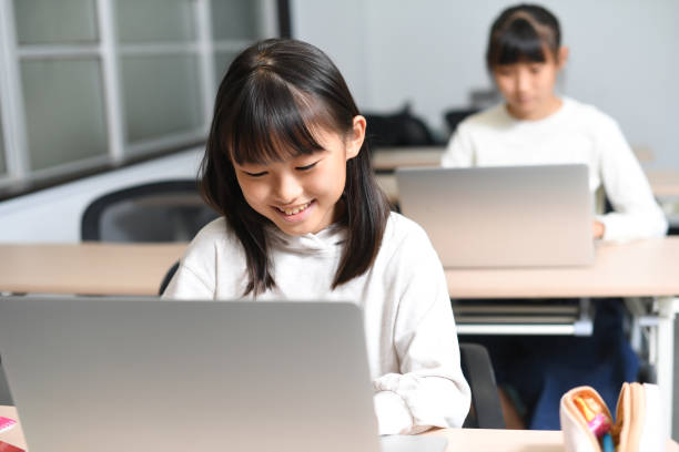 istock Several Asian elementary school girls participate in class using laptops in the classroom. 1891051013