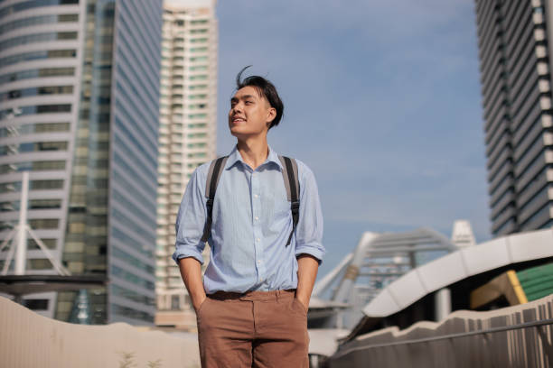 A young businessman confidently walks in the downtown district on his way to his office.