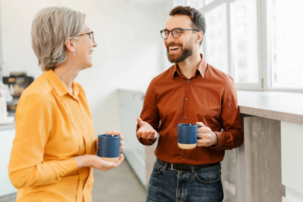 istock Overjoyed business colleagues drinking coffee together in modern office 1891127620