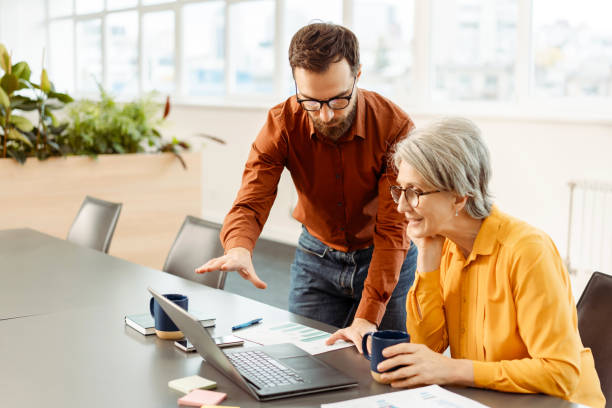 istock Business colleagues using laptop talking, sharing ideas, planning startup, drinking coffee 1891127677