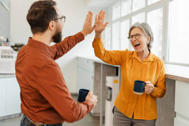 Overjoyed business colleagues giving high five celebration success working together in modern office