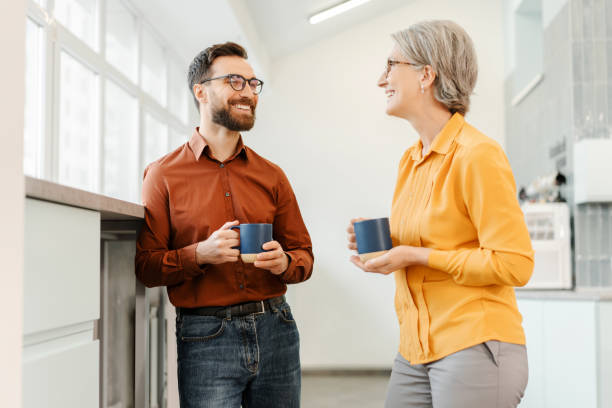 Overjoyed business colleagues drinking coffee together in modern office