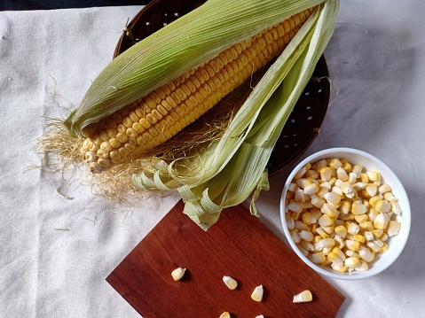 Peeled corn on a white table
