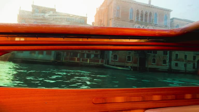 Venice, Italy - March 30, 2021: Grand Canal boat tour at sunset, view from a private moving boat near Rialto Bridge