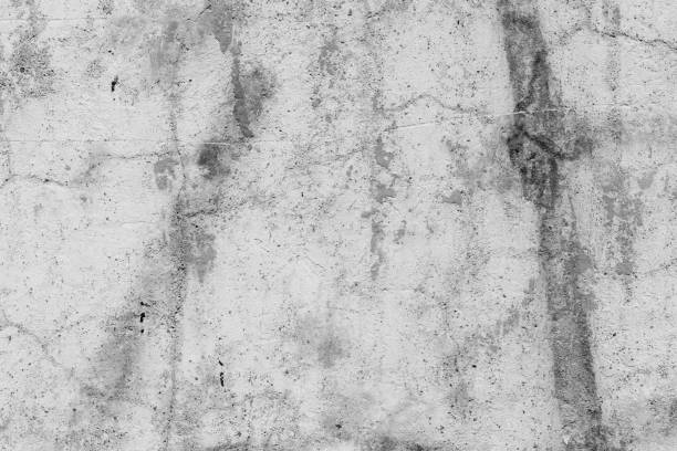 istock Light grey concrete wall with deep scratches and chips. Various variations of abrasions. 1891340452