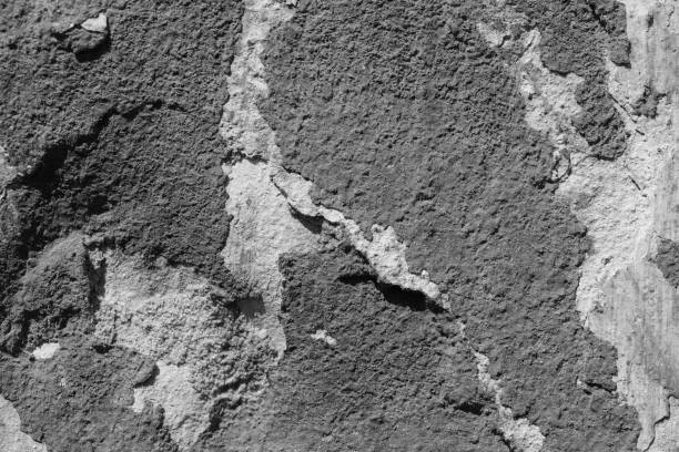 istock Light grey concrete wall with deep scratches and chips. Various variations of abrasions. 1891356565