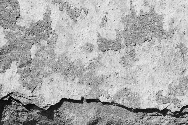 istock Light grey concrete wall with deep scratches and chips. Various variations of abrasions. 1891373654