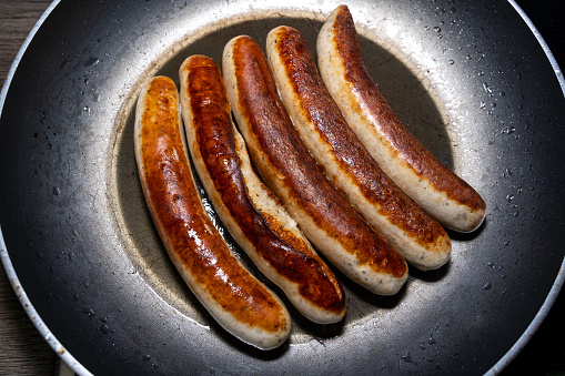 Fried sausages in a pan with oil