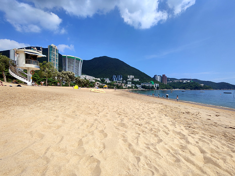 People in the background, walking at Repulse Bay beach, Hong Kong island South coastline famous beach.