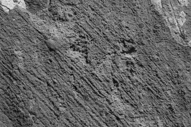 istock Light grey concrete wall with deep scratches and chips. Various variations of abrasions. 1891422736
