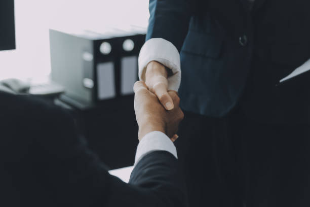 Businessman shaking hands to seal a deal with his partner lawyers or attorneys discussing a contract agreement Businessman shaking hands to seal a deal with his partner lawyers or attorneys discussing a contract agreement 3381 stock pictures, royalty-free photos & images