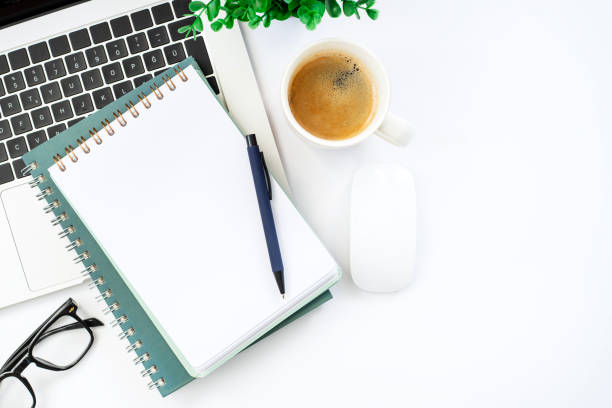 istock Modern white office desk table with coffee, notebook and other supplies. Blank copy space for the text. Top view, flat lay. 1891636254
