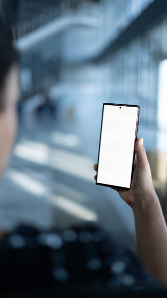 istock Woman holding phone with white screen in office lobby , mock-up screen 1891660061