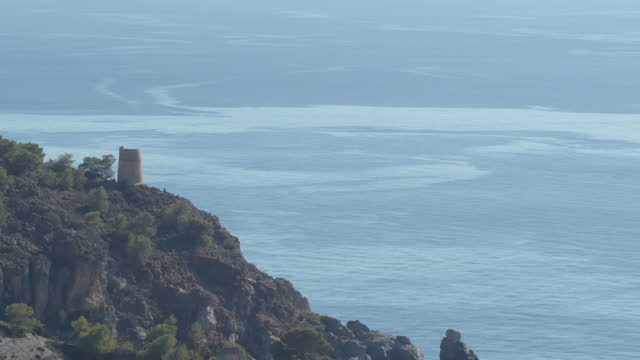 Watchtower of La Caleta or El Cañuelo with a blue sea, Nerja, Spain