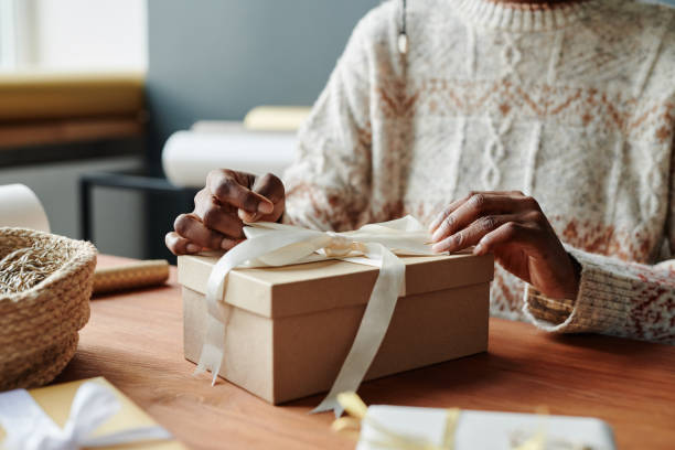 istock Young woman tying up ribbon on giftbox 1891742339