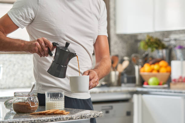 istock Crop man pouring coffee from moka pot in cup 1891757070