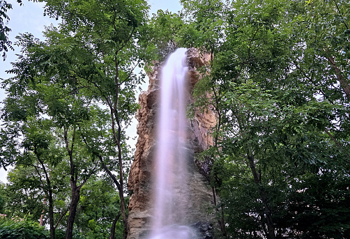 Waterfall falling from a small rock between trees\n\n나무 사이 작은 바위에서 떨어지는  폭포