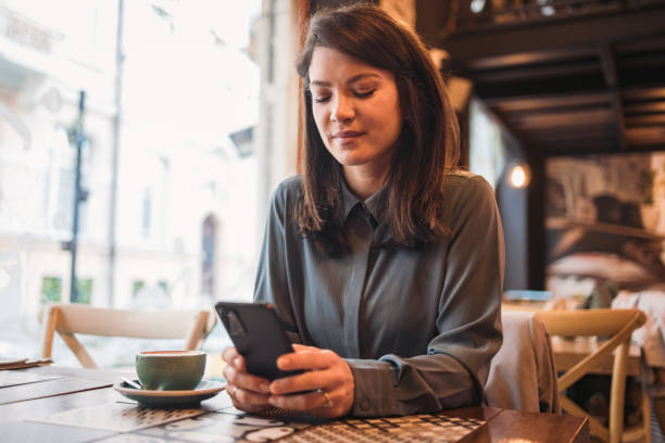 istock Beautiful woman using phone while sitting in cafe, break from work 1891772139