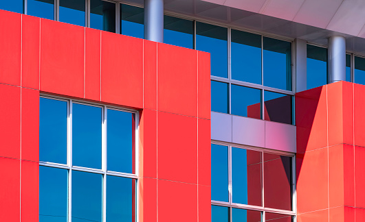 Red and gray aluminium composite tiles with glass wall decoration on exterior modern office building wall