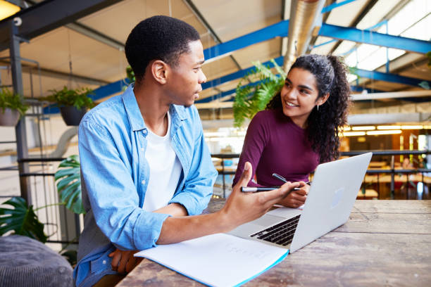 istock Two college students doing homework together in a campus lounge 1891823040