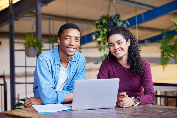 istock Smiling college students doing homework together in a campus lounge 1891832045