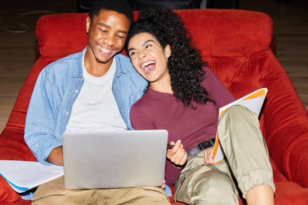 istock Laughing college students doing homework in a chair in a campus lounge 1891835748