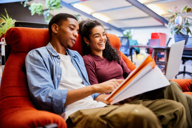 istock College students laughing while doing homework together in a campus lounge 1891840053