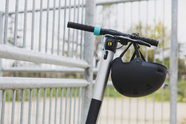 istock Electric scooter handlebar with black safety helmet. 1891894225