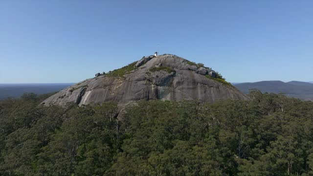 Tilt down reveal from the blue sky to the large granite slab of Mount Frankland.