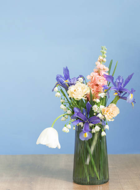 istock spring flowers in glass vase on blue background 1891926498