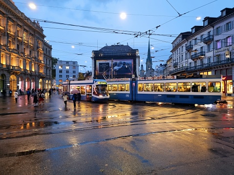 The Paradeplatz in the heart of Zurich City where arround are located the biggest banks of Switzerland. The Paradeplatz is also a main connection point where several tram lines are crossing and the people using public transportation have to change the lines. The image was captured at dusk.