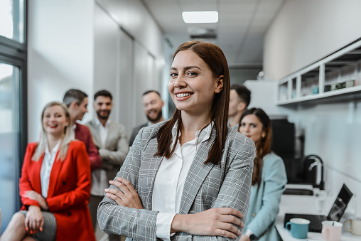 Staff Members Supporting Smiling Businesswoman