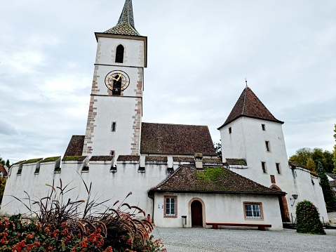 The Fortified Church of St. Arbogast in the municipality of Muttenz in the Swiss canton of Basel-Land is the only church in Switzerland that is surrounded by a defensive wall. The image was capture during autumn season.