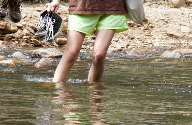 Young woman wading through river