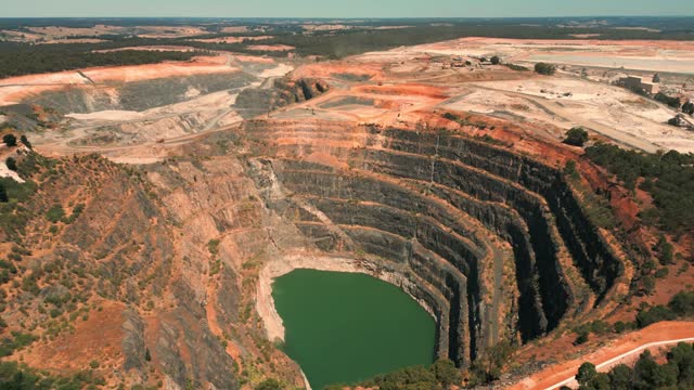 drone shot revealing an abandoned mine pit and a mining site in the background in western Australia