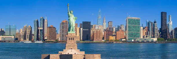 Statue of Liberty and New York City Skyline with UN Building, Chrysler Building, Empire State Building and Skyscrapers of Manhattan East Side in the Morning, NY, USA. stock photo