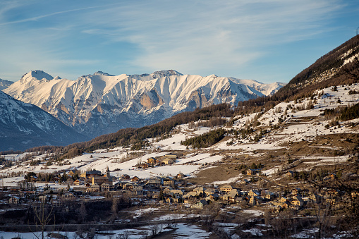 As the golden hour descends upon Notre Dame de Laus, the play of light and shadow accentuates the timeless allure of this French alpine village. It's a scene that feels plucked from a postcard, where each chalet whispers tales of yesteryear against the dramatic backdrop of the snow-kissed mountains.