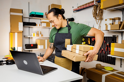 Busy man prepares packages for customers
