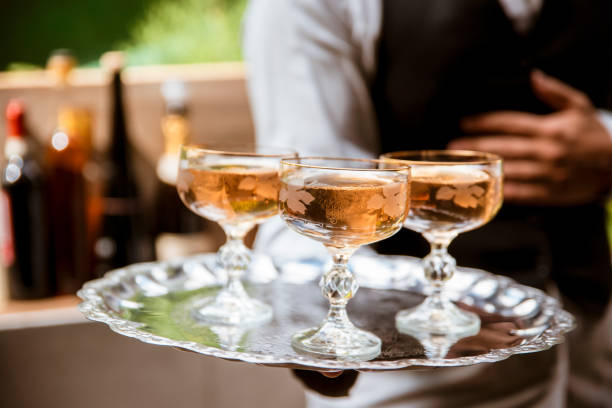 mayordomo, bandeja de tres copas con vino blanco - waiter butler champagne tray fotografías e imágenes de stock