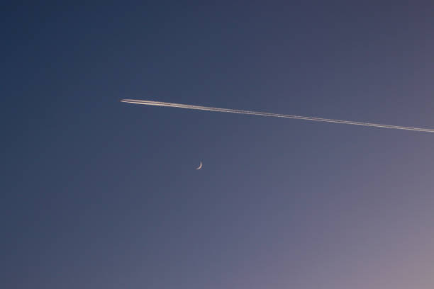 Chemtrails from airplanes in the evening sky Chemtrails from airplanes in the evening sky contrail moon on a night sky stock pictures, royalty-free photos & images