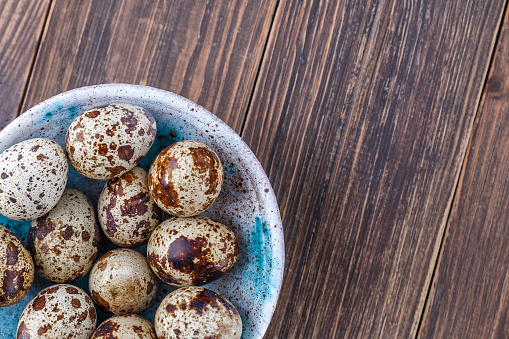 Quail eggs on the wooden plate. Quail eggs can be consumed by frying or boiling. In Indonesia quail eggs called telur puyuh.