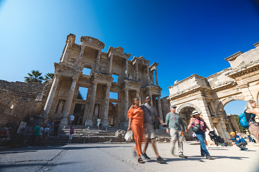 Travelers wander around the historic Library of Celsus at the archeological site of Ephesus, capturing the essence of cultural heritage.