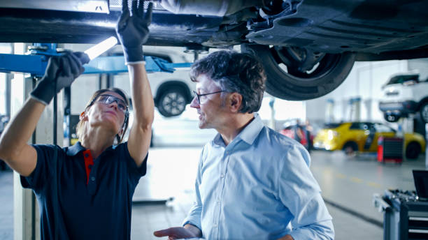 istock Female Mechanic And Manager Discussing Repairs Underneath Car At Workshop 1892163896