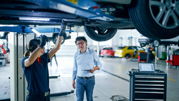 istock Female Mechanic And Manager Collaboratively Check Repairs Underneath A Car 1892164071