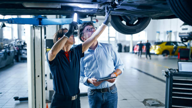 istock Female Mechanic And Manager Discussing Repairs Underneath Car At Workshop 1892164073